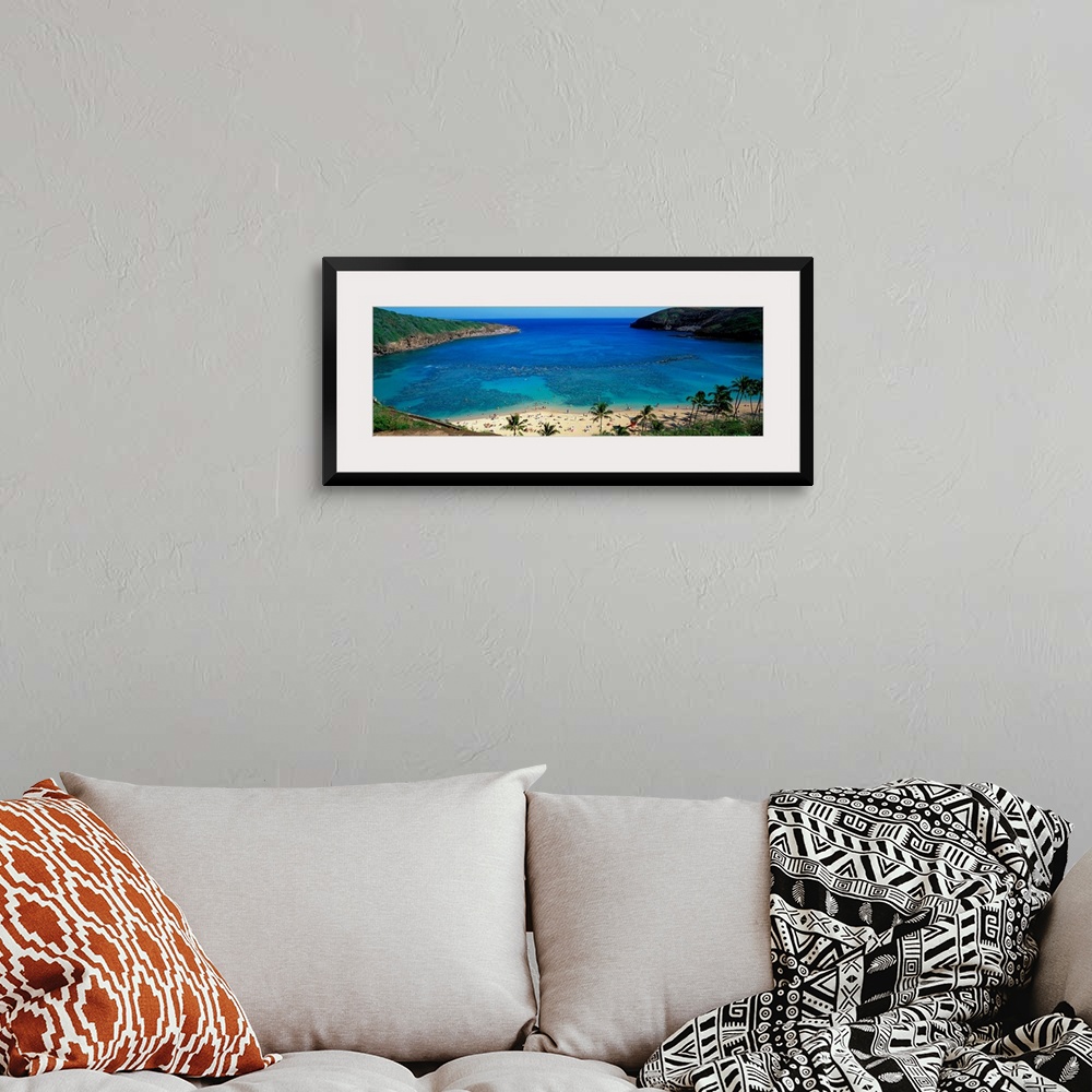 A bohemian room featuring High angle panoramic of a harbor on a tropical island and tourist sunbathing on the shore.