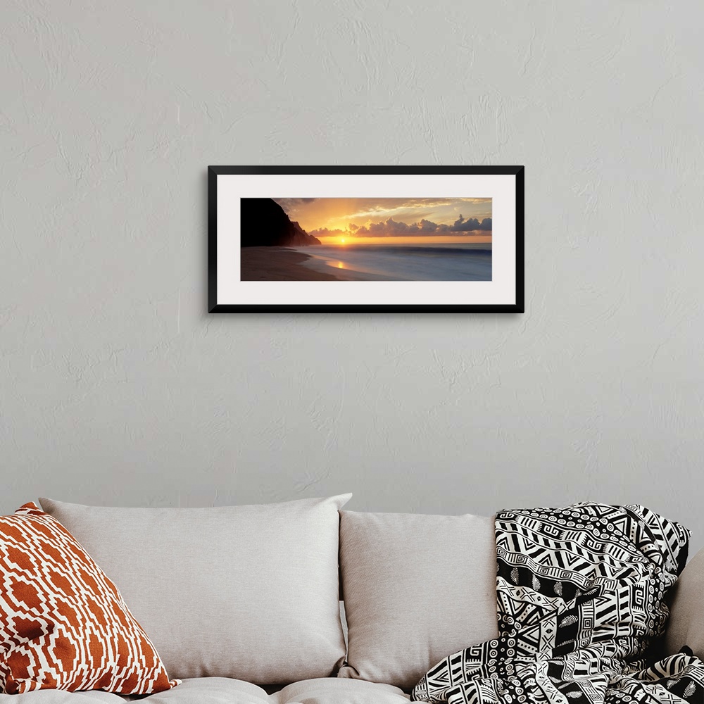 A bohemian room featuring The sun sinks below the horizon viewed from the beach on a tropical Pacific island.