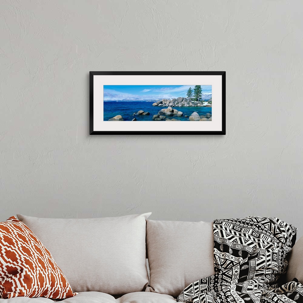 A bohemian room featuring A panoramic photograph taken at eye level this home wall art shows the boulder covered shores of ...