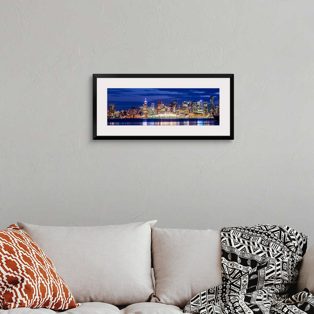 A bohemian room featuring Panoramic photograph of the Vancouver, British Columbia skyline lit up on a dark purple night and...