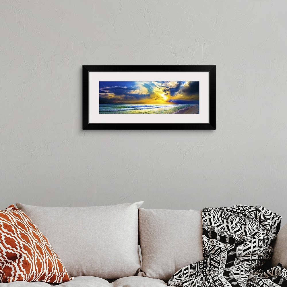 A bohemian room featuring A bright yellow sunset sky over waves as the hit the beach in this beautiful landscape. A beautif...