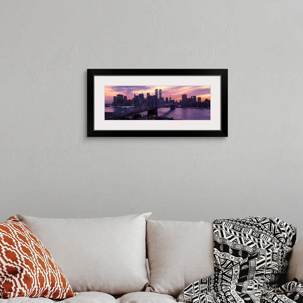 A bohemian room featuring This wall hanging is a panoramic photograph captures the fading sun as skyscrapers begin to turn ...