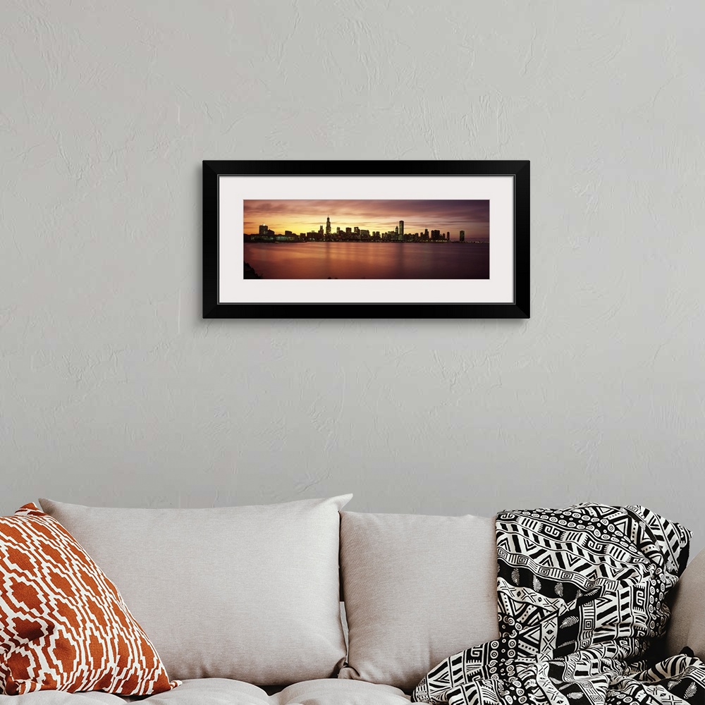 A bohemian room featuring Wide angle, distant photograph of lit skyscrapers of Chicago, over the waters of Lake Michigan, a...