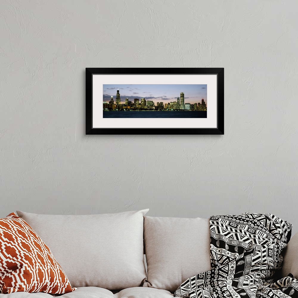 A bohemian room featuring Panoramic photograph displays a horizon filled with tall skyscrapers and buildings as the sun beg...