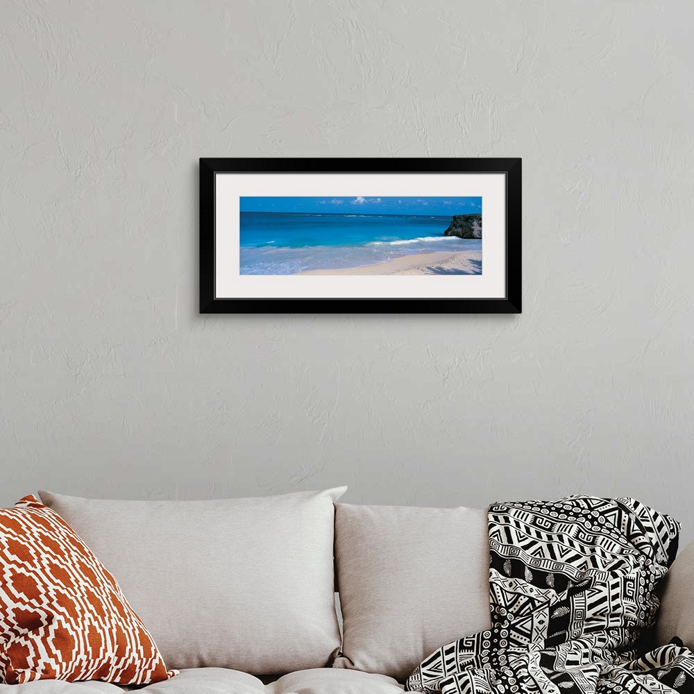 A bohemian room featuring This is a panoramic photograph of small waves breaking on a sandy tropical beach.