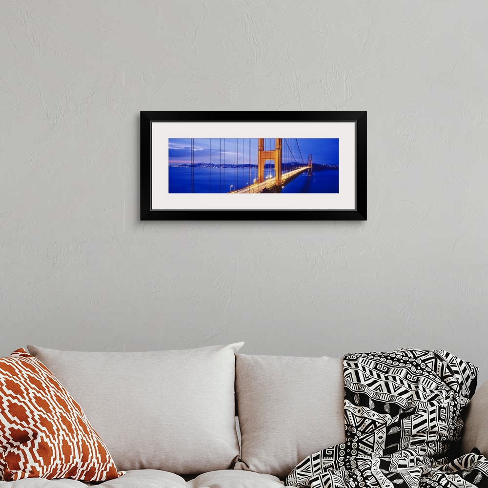 A bohemian room featuring Long and narrow photo print of an up close view of the Golden Gate Bridge lit up at night with ca...