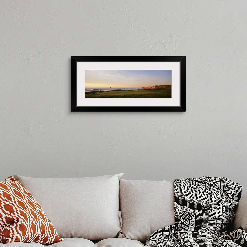 A bohemian room featuring Panoramic photograph on a large canvas of the green on a golf course, along the coast of Half Moo...
