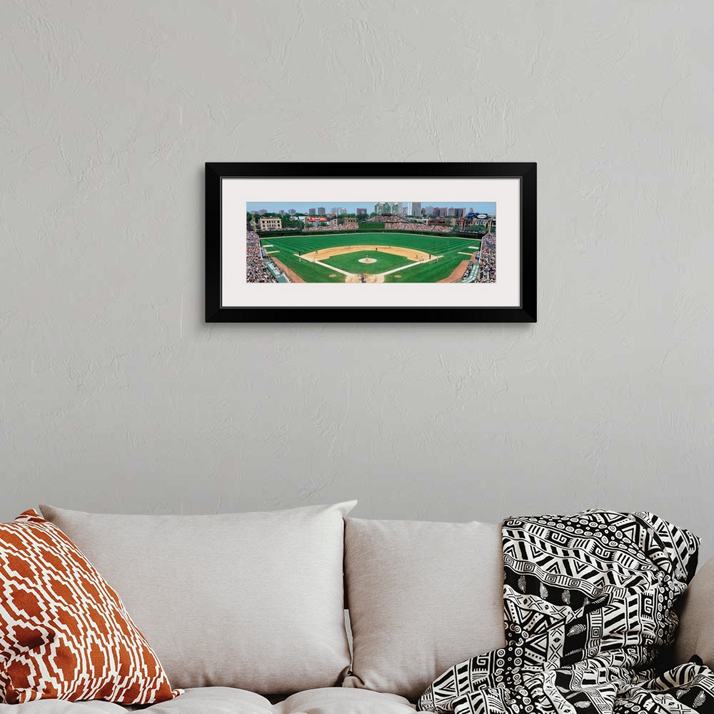 A bohemian room featuring Panoramic photograph of Wrigley Field with Chicago skyline in the distance.  Stadium is full of p...