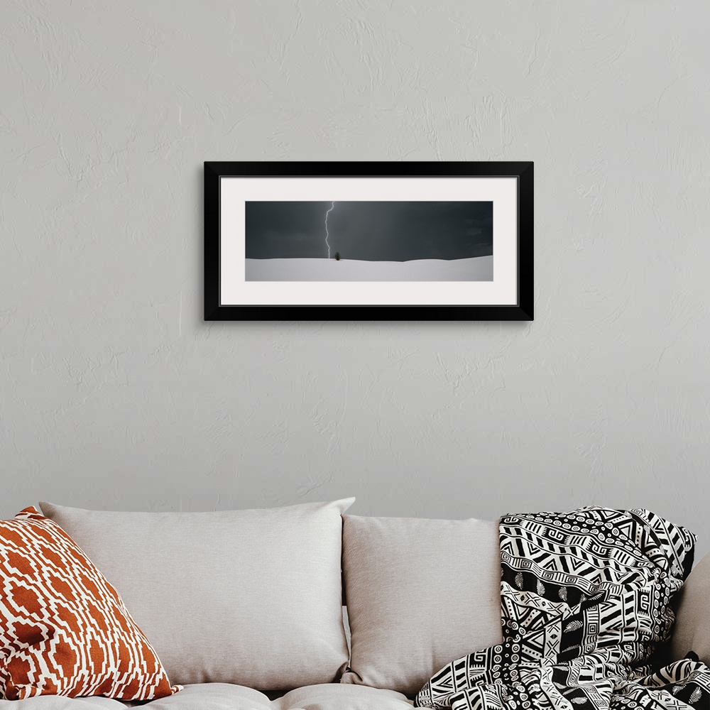 A bohemian room featuring Panoramic photo print of a lightning strike hitting behind a plant near a sand dune.