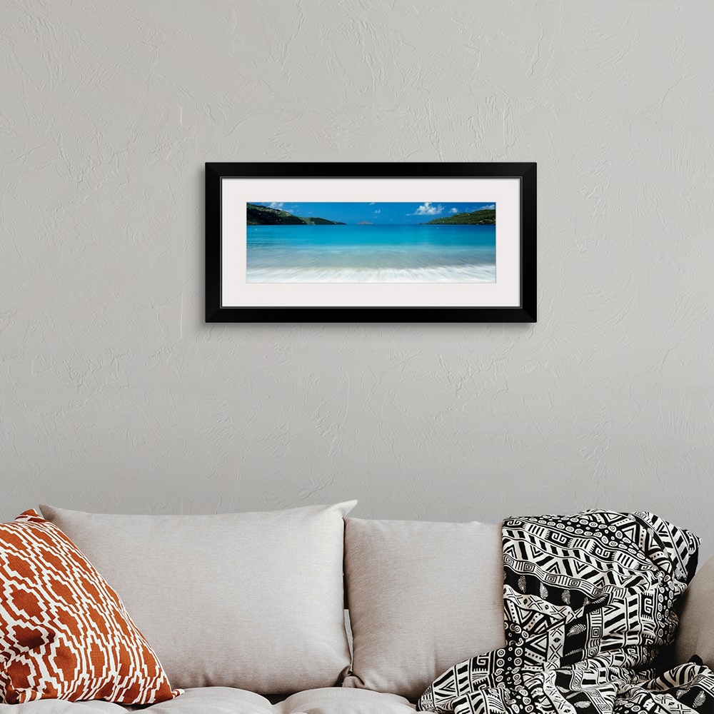 A bohemian room featuring Panoramic photograph of clear water in a calm sea washing up a tropical beach.
