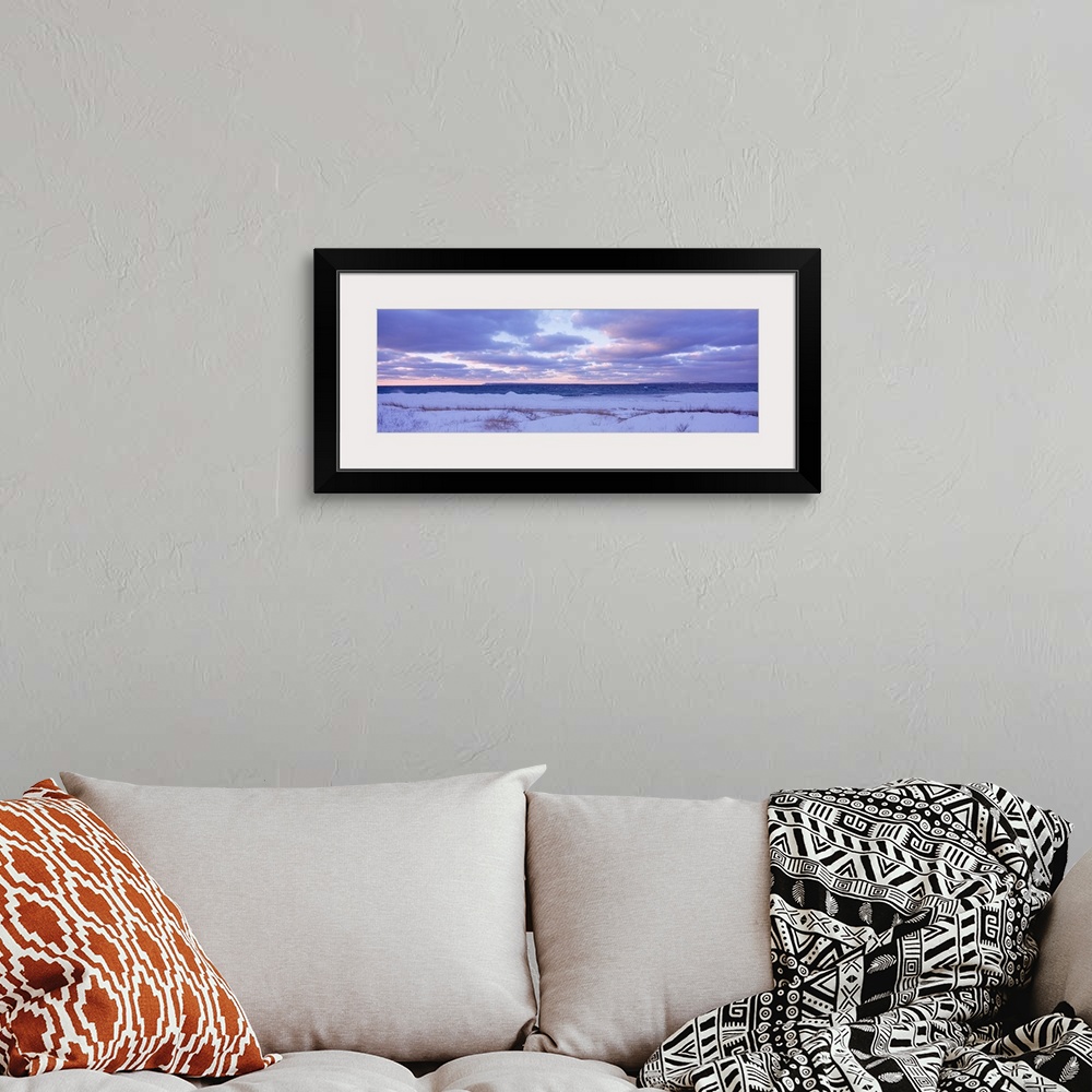 A bohemian room featuring Large, wide angle photograph of a beach off of Lake Michigan, under a sky of pastels and clouds a...