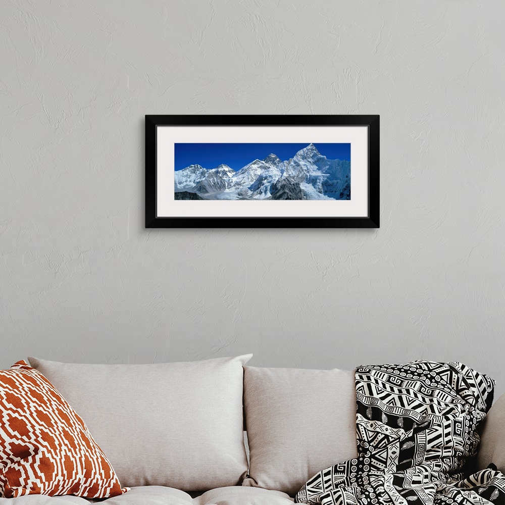 A bohemian room featuring Giant, wide angle landscape photograph of snow covered Himalaya Mountains against a blue sky, inc...