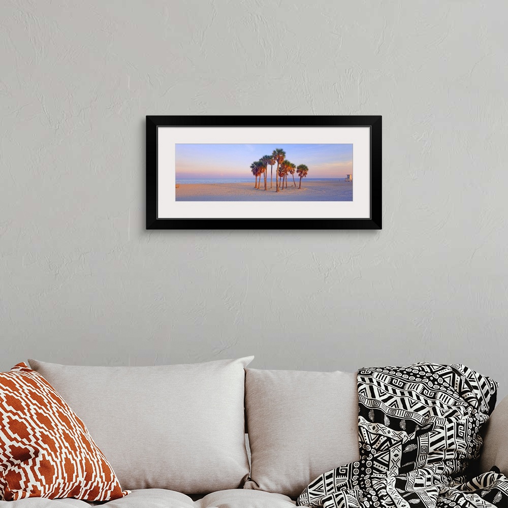 A bohemian room featuring Panoramic photograph of tree cluster on shoreline with ocean in distance at dusk.