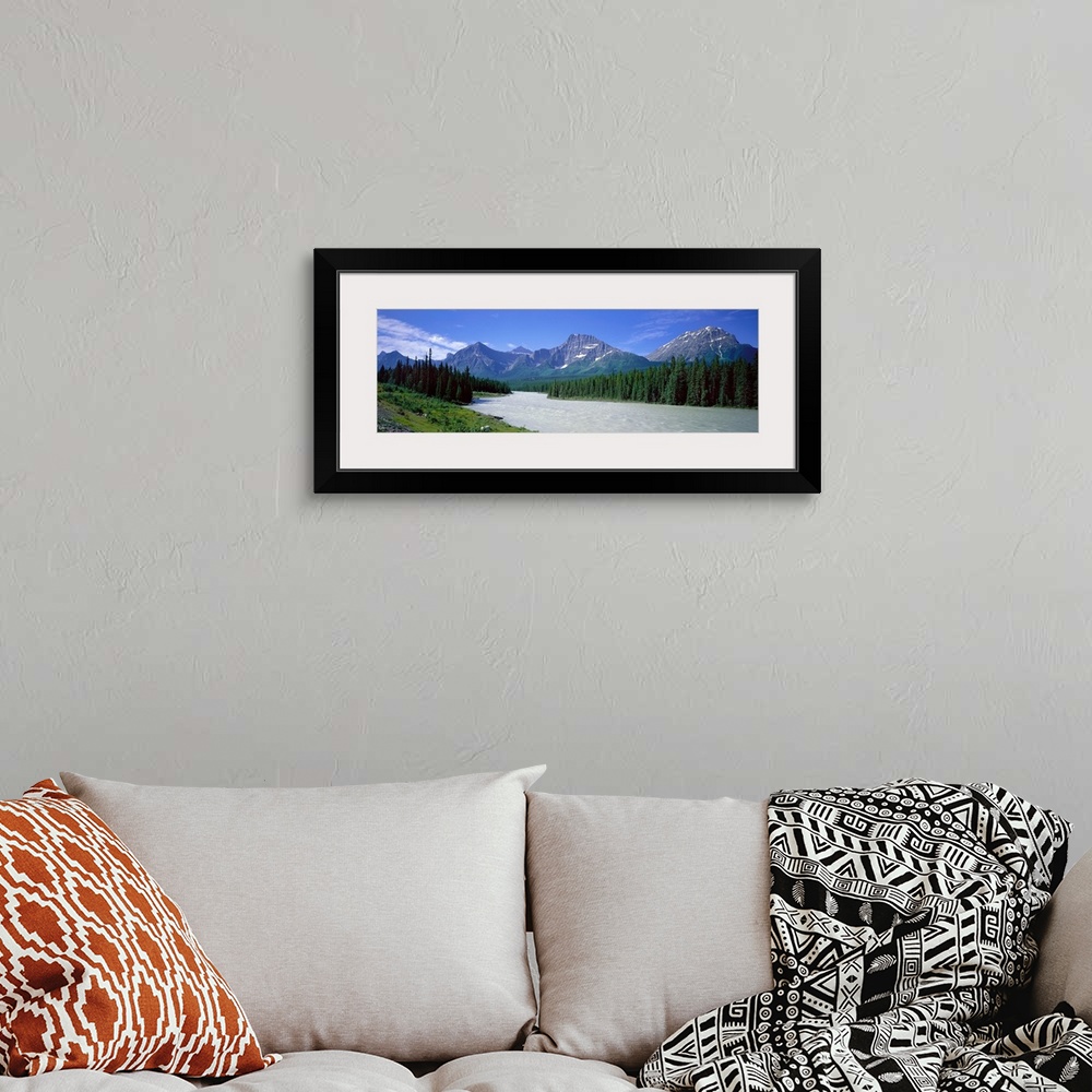 A bohemian room featuring Panoramic photograph of river winding through forest with mountain range in the distance under a ...
