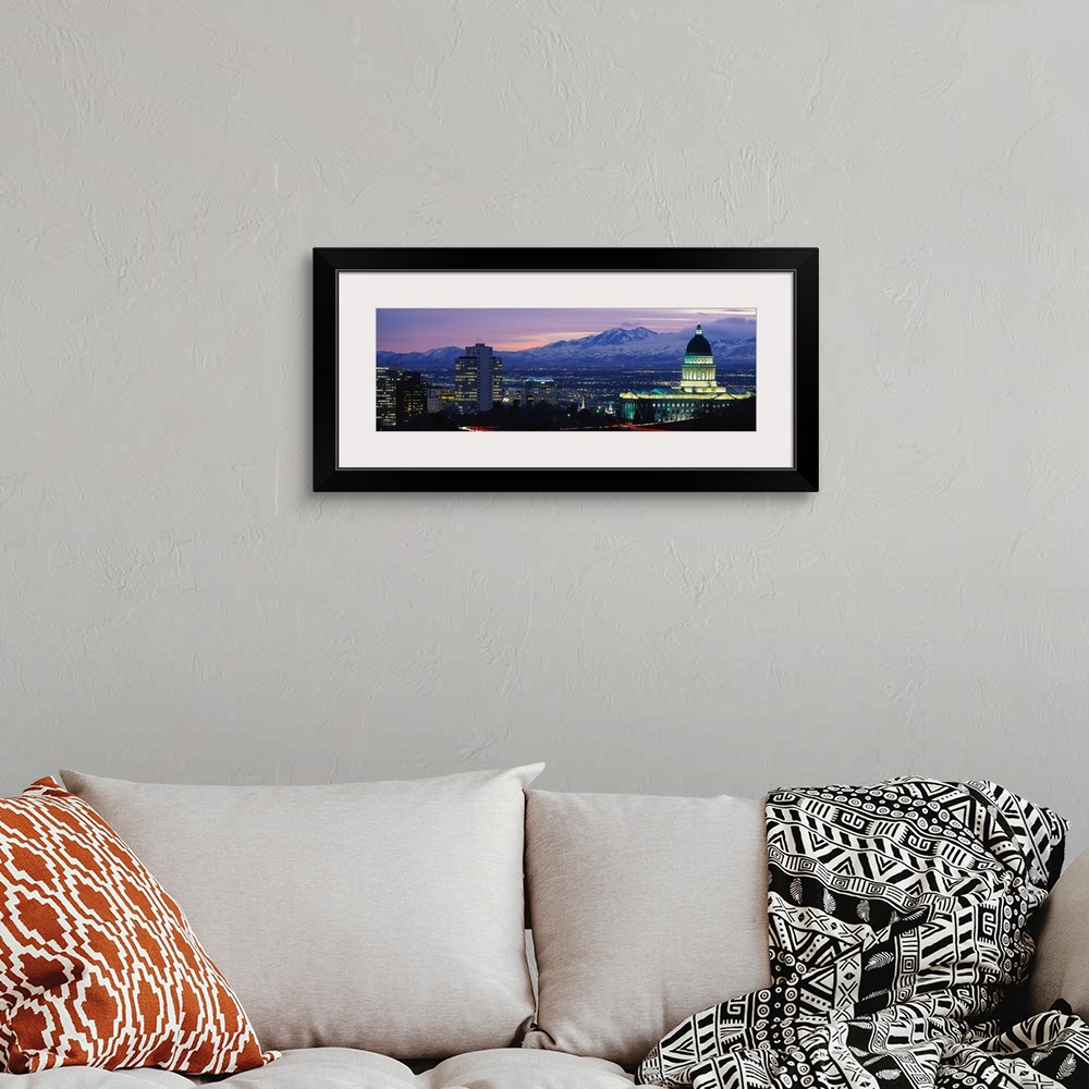 A bohemian room featuring Panoramic Rocky Mountains and downtown Salt Lake City, Utah as the last of the sun dips below the...