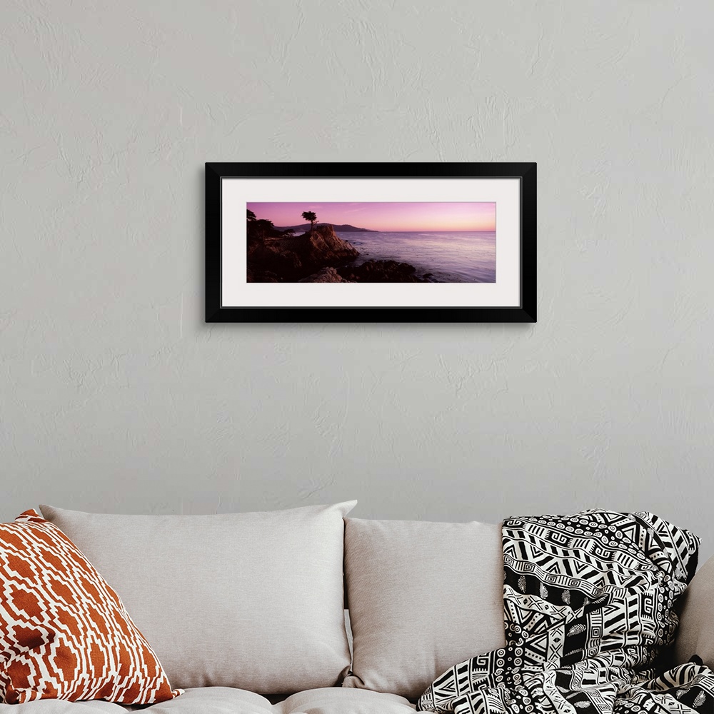 A bohemian room featuring Landscape photograph on a large wall hanging of a silhouetted cypress tree on the edge of a rocky...