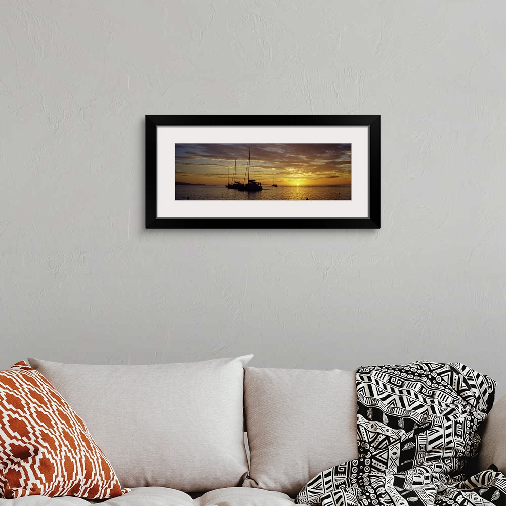 A bohemian room featuring Panoramic photograph on a big wall hanging of several silhouetted sailboats, floating on calm wat...