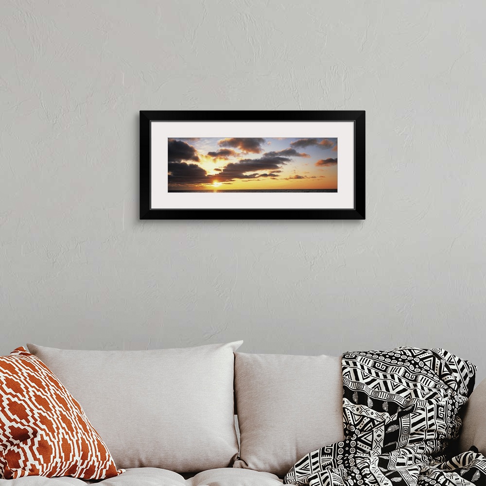 A bohemian room featuring Wide angle photograph of the sun setting slightly behind clouds, over the vast waters of Lake Mic...