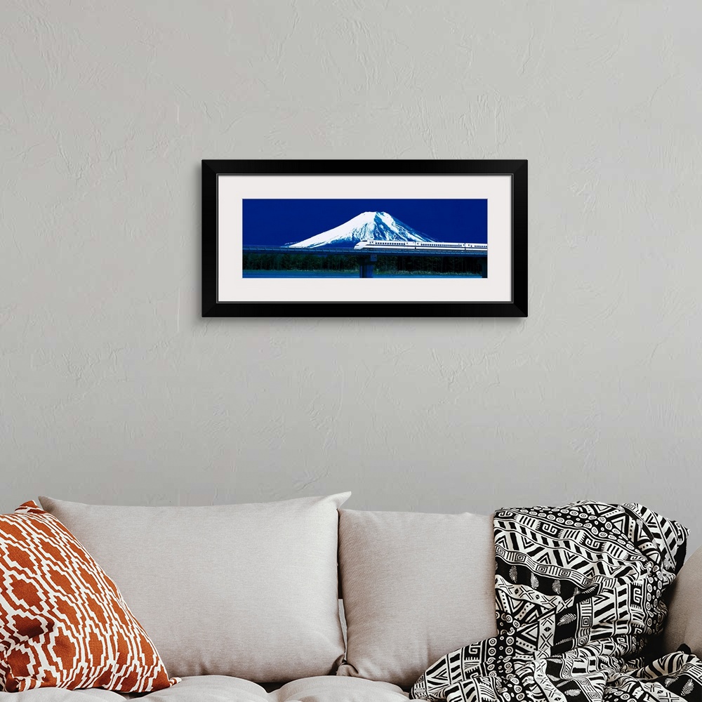 A bohemian room featuring Panoramic photo on canvas of a train going across a bridge above water with a snowy mountain the ...