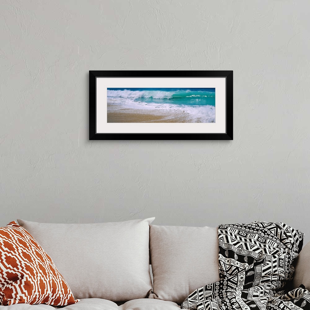 A bohemian room featuring Panoramic photograph of water crashing onto the sand and being swept back out to sea.