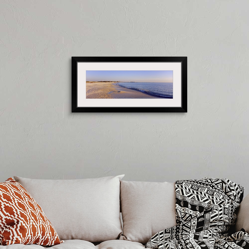 A bohemian room featuring Panoramic photograph looking down the shoreline of Fort Myers Beach beneath a blue sky, in the Gu...