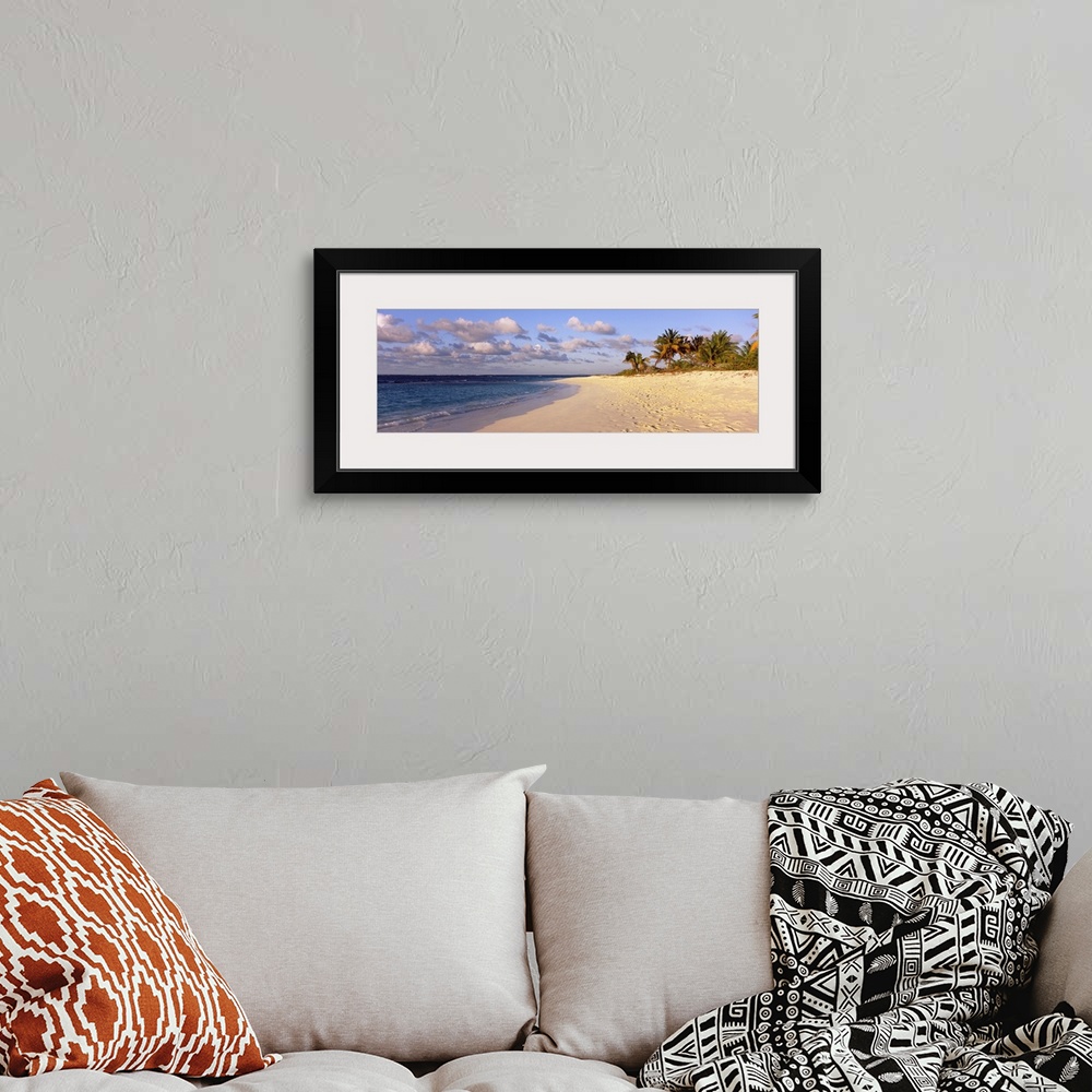 A bohemian room featuring Big panoramic photo of waves trickling onto the Shoal Bay Beach in Anguilla. Fooprints can be see...