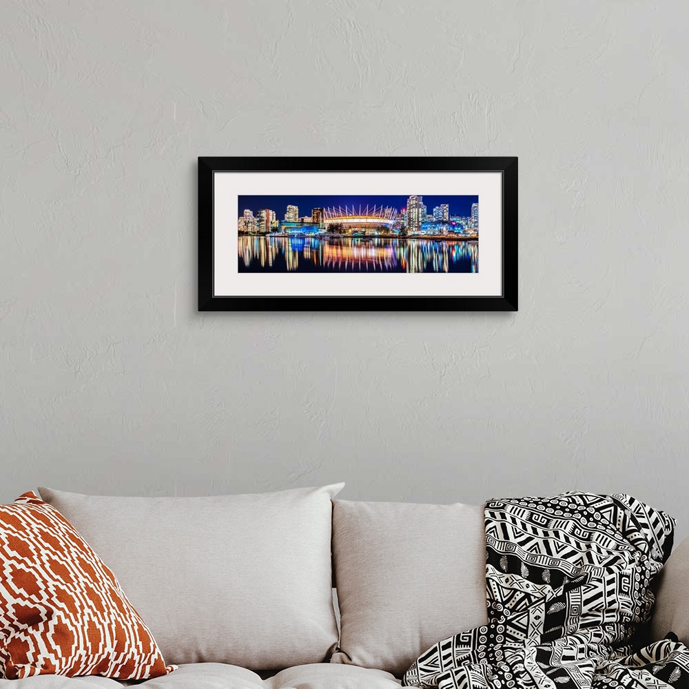 A bohemian room featuring Panoramic photograph of BC Place Stadium and part of the Vancouver skyline lit up at night and re...