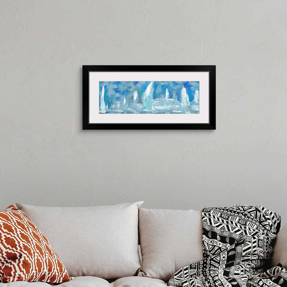 A bohemian room featuring Horizontal artwork of a group of white sailboats against a blue sky.