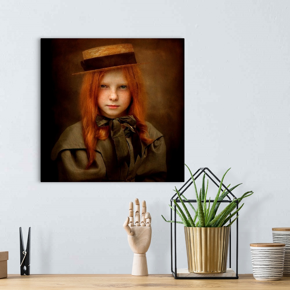A bohemian room featuring A child with long red hair wearing a straw hat and a ribbon tied in a bow.