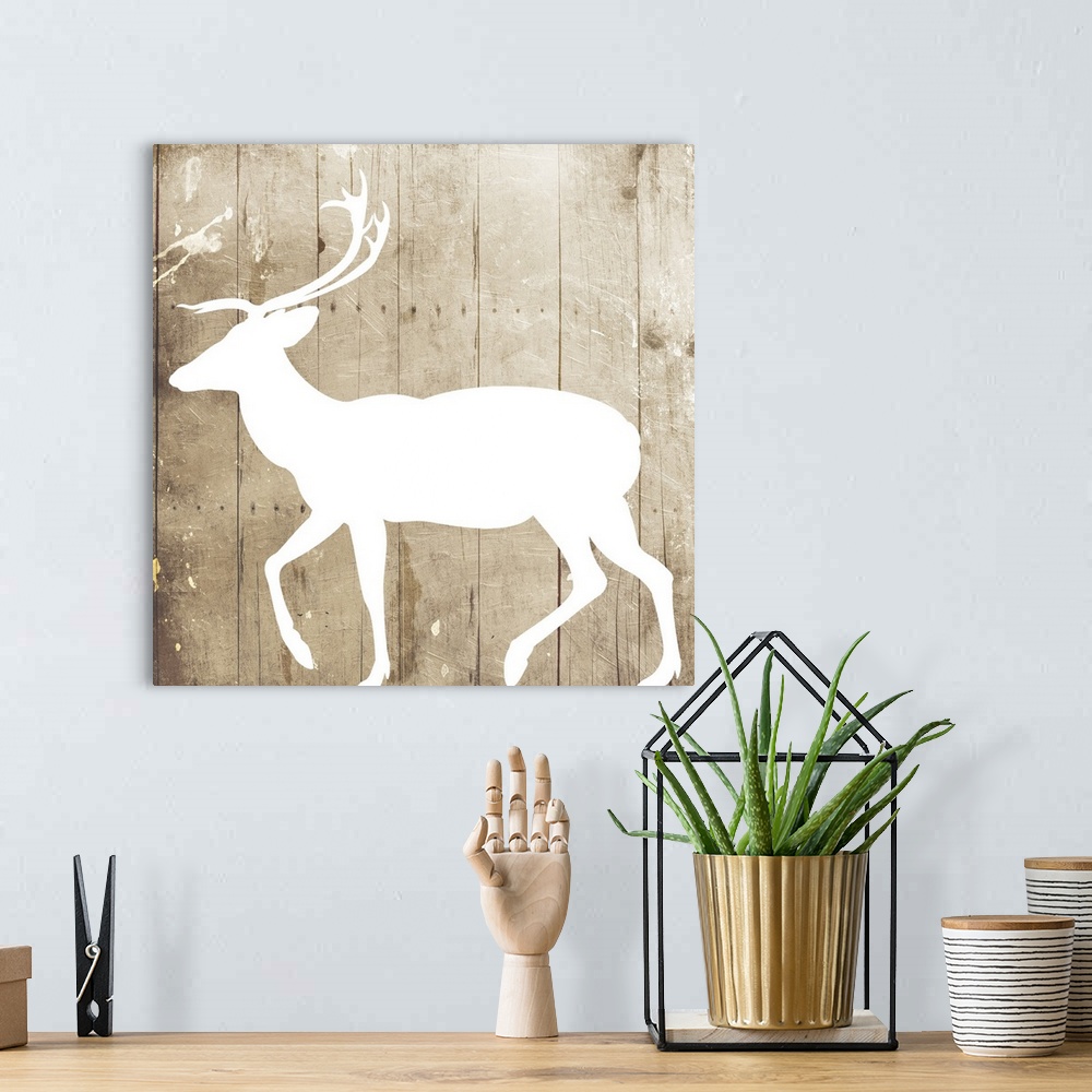A bohemian room featuring A white silhouette of a deer painted on a wood background.