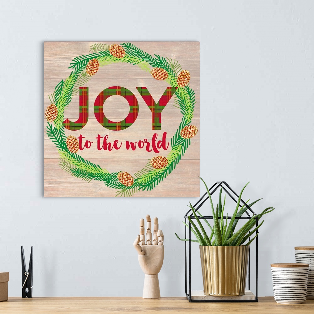 A bohemian room featuring "Joy To The World" written inside of a Winter wreath in blue, green, and gold hues on a faux wood...