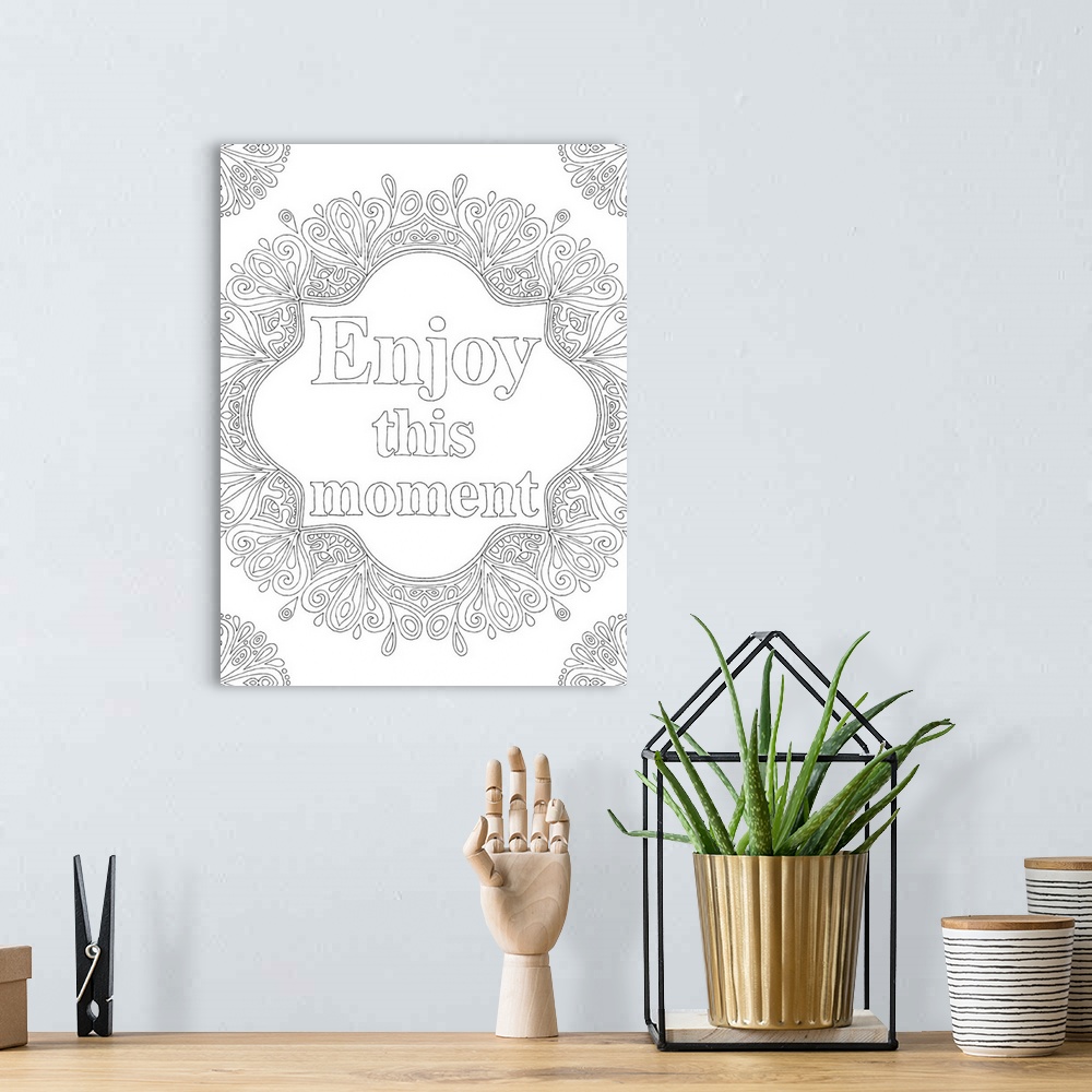 A bohemian room featuring Black and white line art with the phrase "Enjoy this moment" written in the center and curvy desi...