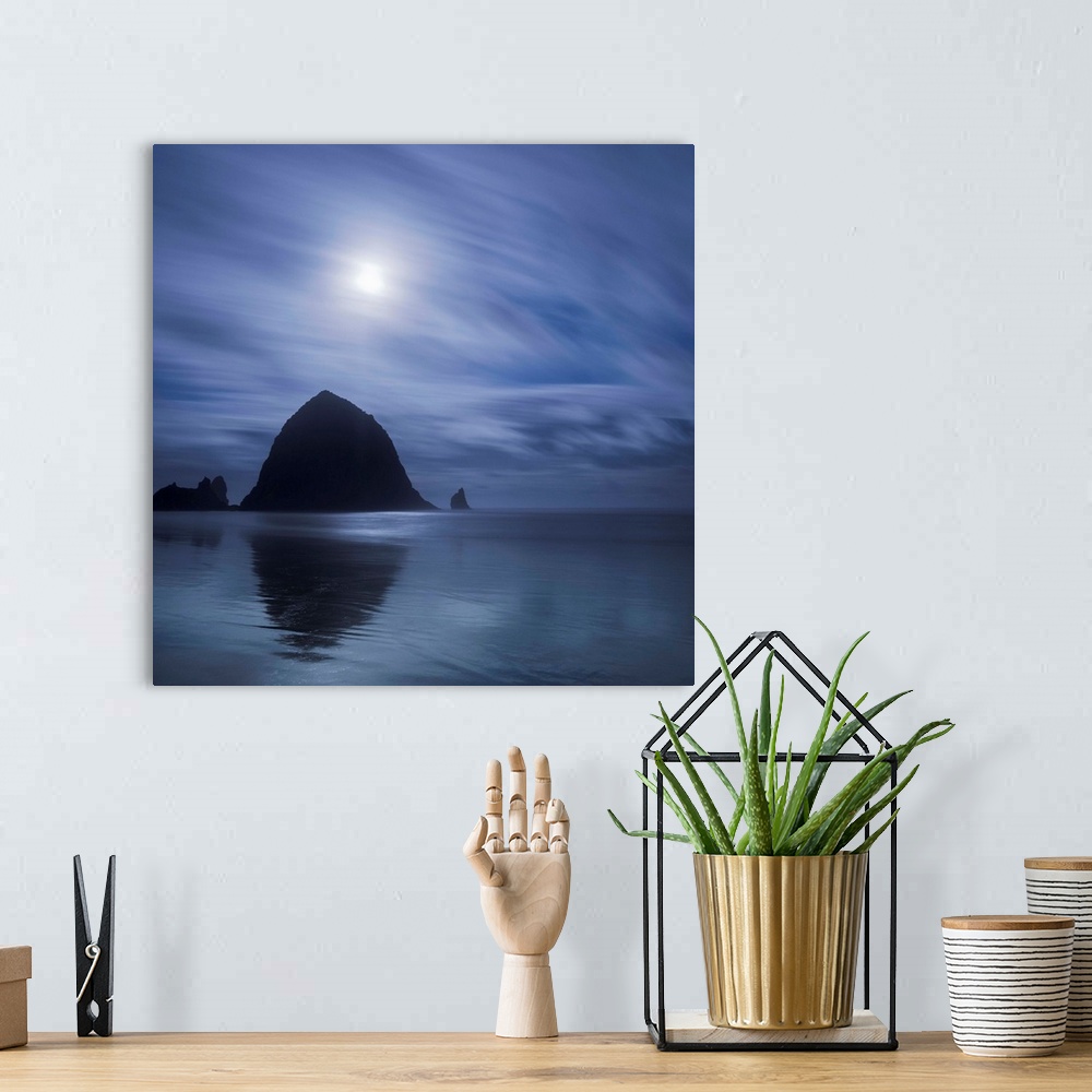 A bohemian room featuring An artistic photograph of a silhouetted Canon beach in Oregon.