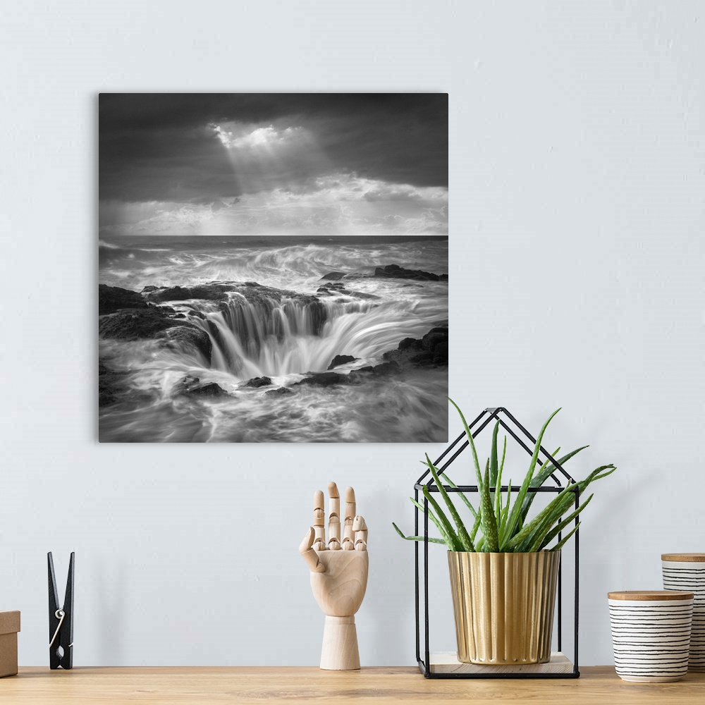 A bohemian room featuring An artistic black and white photograph of a tidal pool with rushing water flowing in and around t...