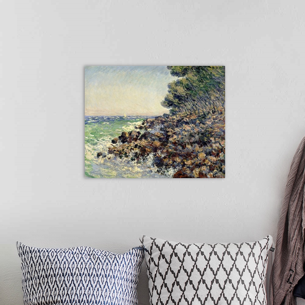 A bohemian room featuring Impressionist oil painting by Claude Monet of a rocky beach shore overlooking the ocean.