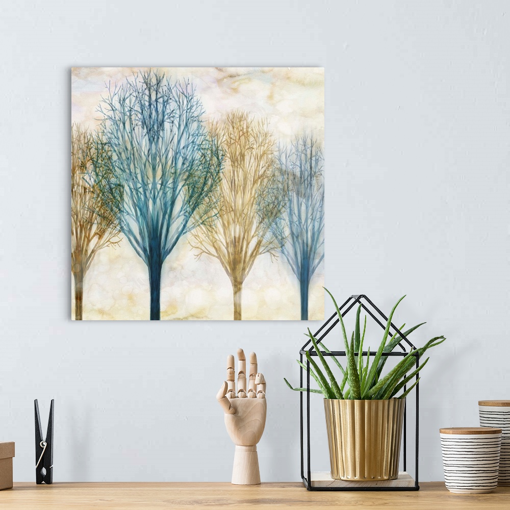 A bohemian room featuring Square artwork with Winter trees in blue and brown hues with a foggy sepia toned background.