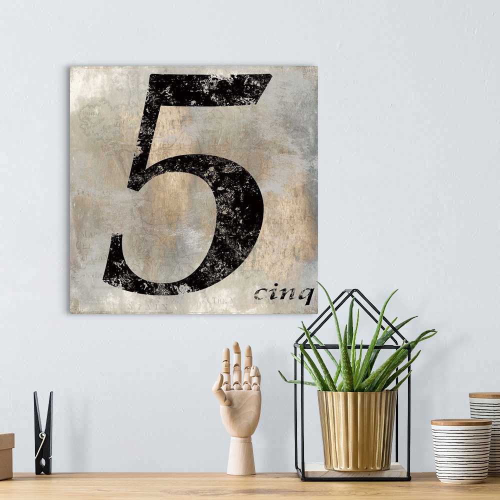 A bohemian room featuring French 5 sign in black, gold, and gray hues with a faint illustration of a map on the background.