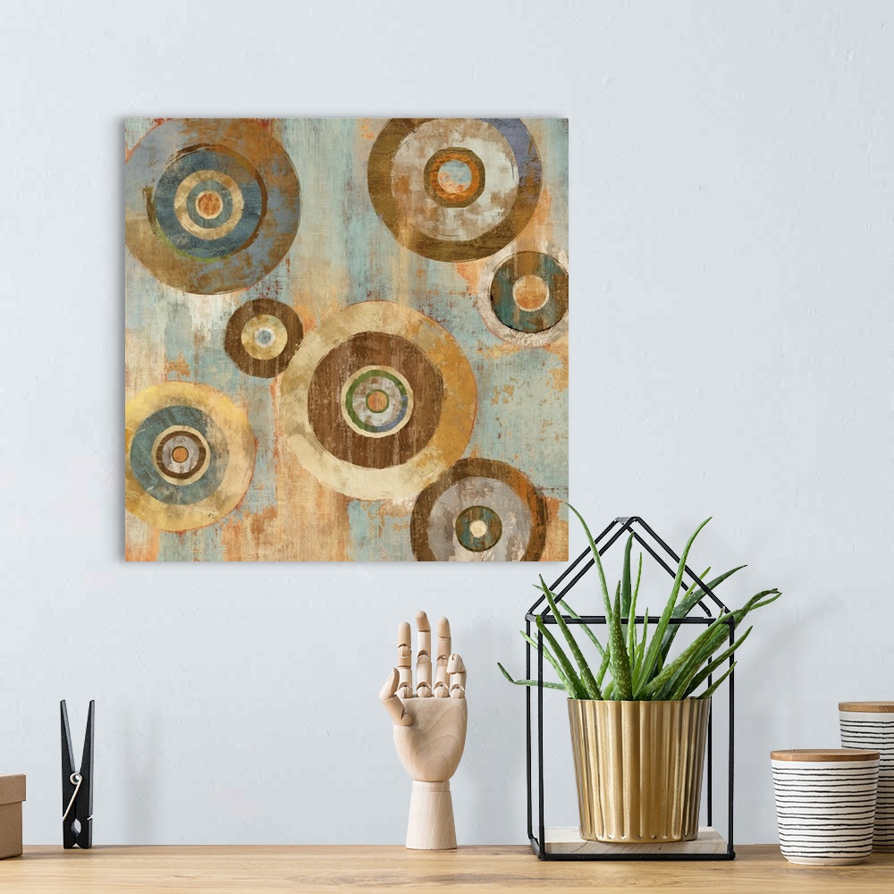 A bohemian room featuring Square abstract decor with colorful circles around circles on a blue, cream, and gold background.