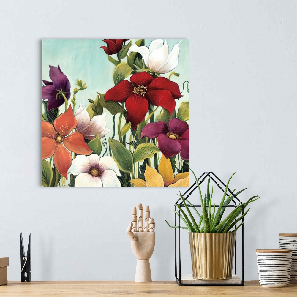 A bohemian room featuring Square painting of a group of multiple colored flowers in a garden against a blue backdrop.