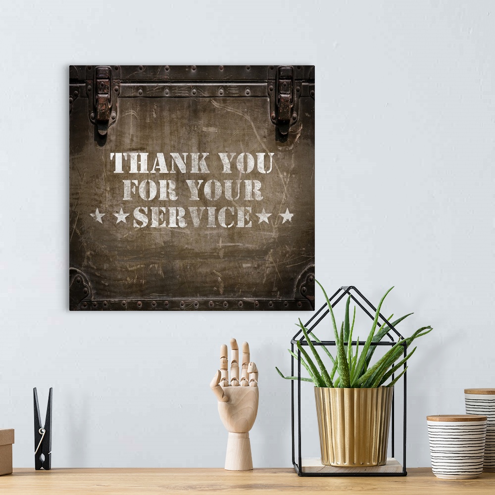 A bohemian room featuring "Thank You For Your Service" stenciled in white on a worn trunk.