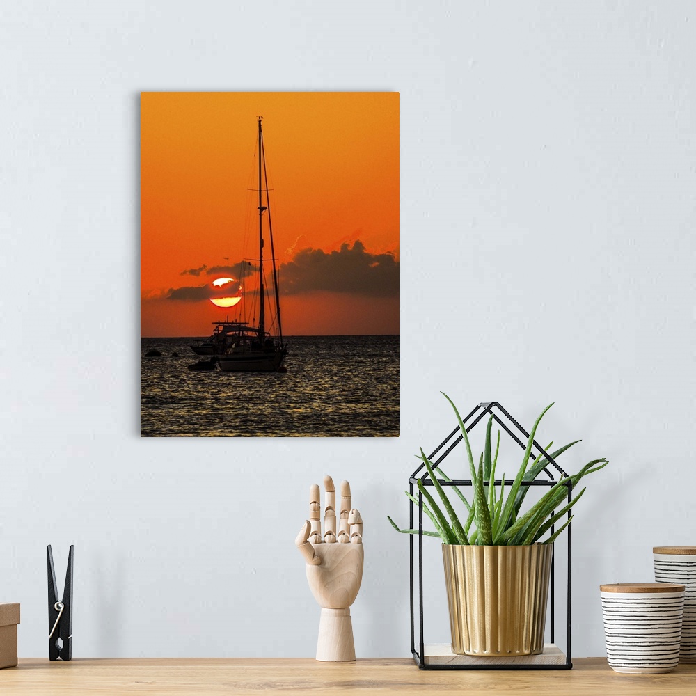 A bohemian room featuring Seven Mile Beach, Grand Cayman. Sailboat and a boat with the orange sun setting behind the clouds...