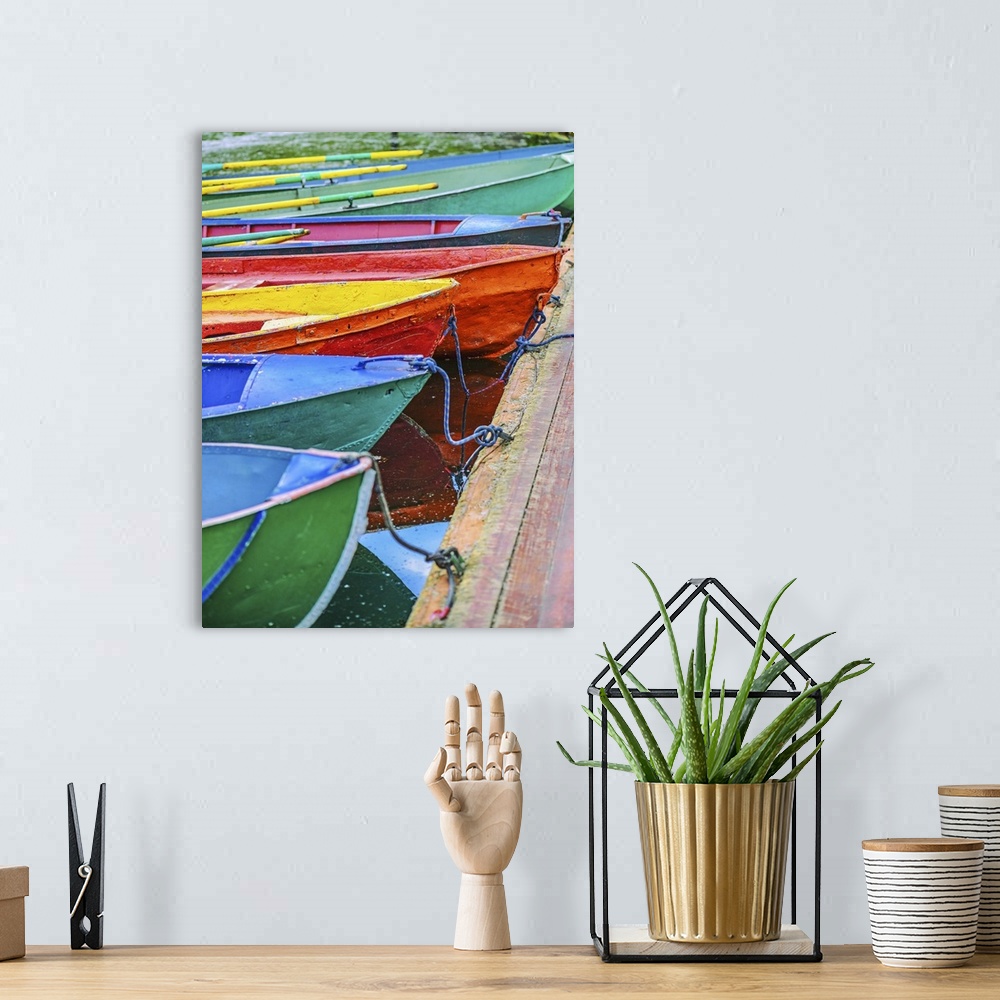 A bohemian room featuring Colorful small boats parked to wooden pier.