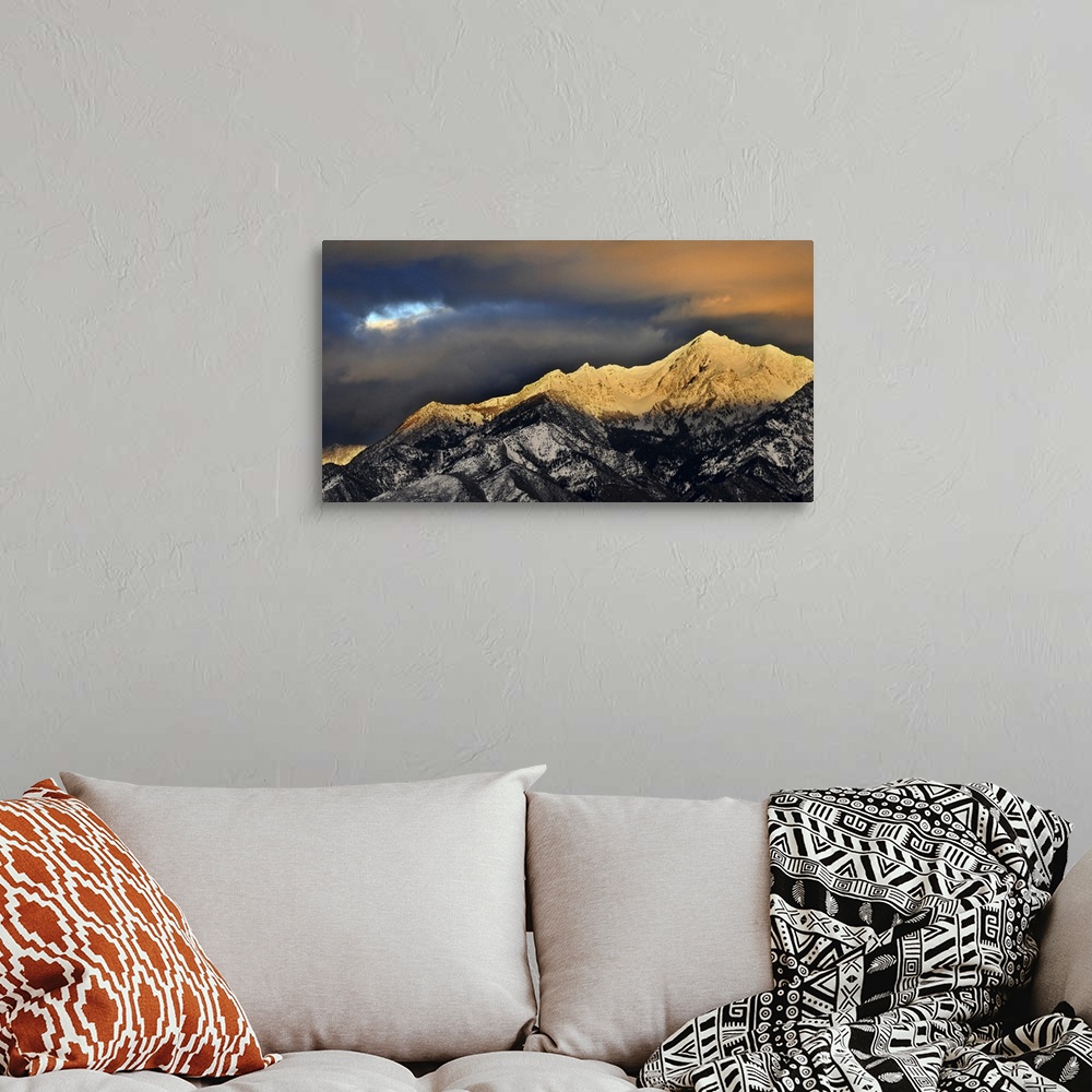 A bohemian room featuring Clouds hover over granite peaks of Wasatch Mountains.