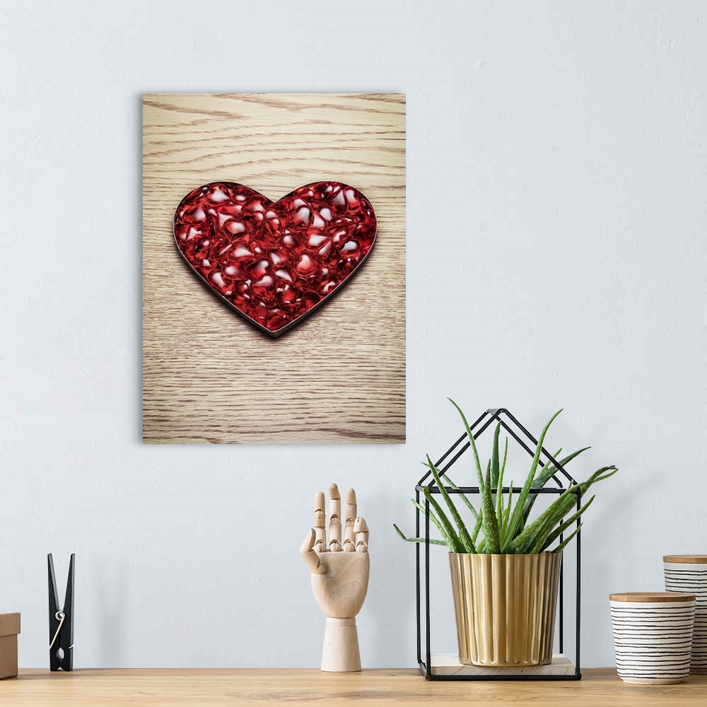 A bohemian room featuring A mass of plastic red hearts sit in a heart shape on a wooden background