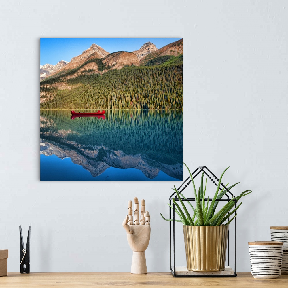 A bohemian room featuring Reflection of mountain and boat in lake Louise, Banff, Alberta.