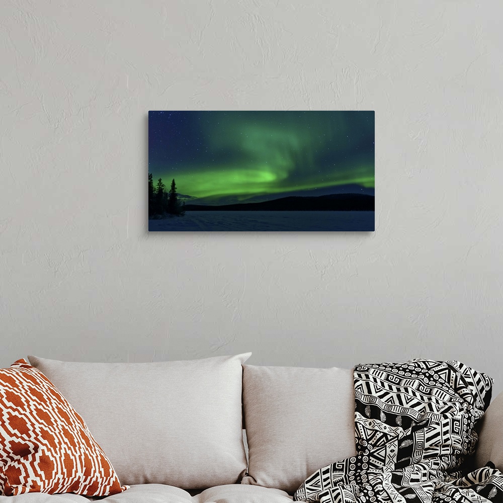 A bohemian room featuring The green light of the Northern Lights (aurora borealis) sparkle above a snow covered frozen lake...