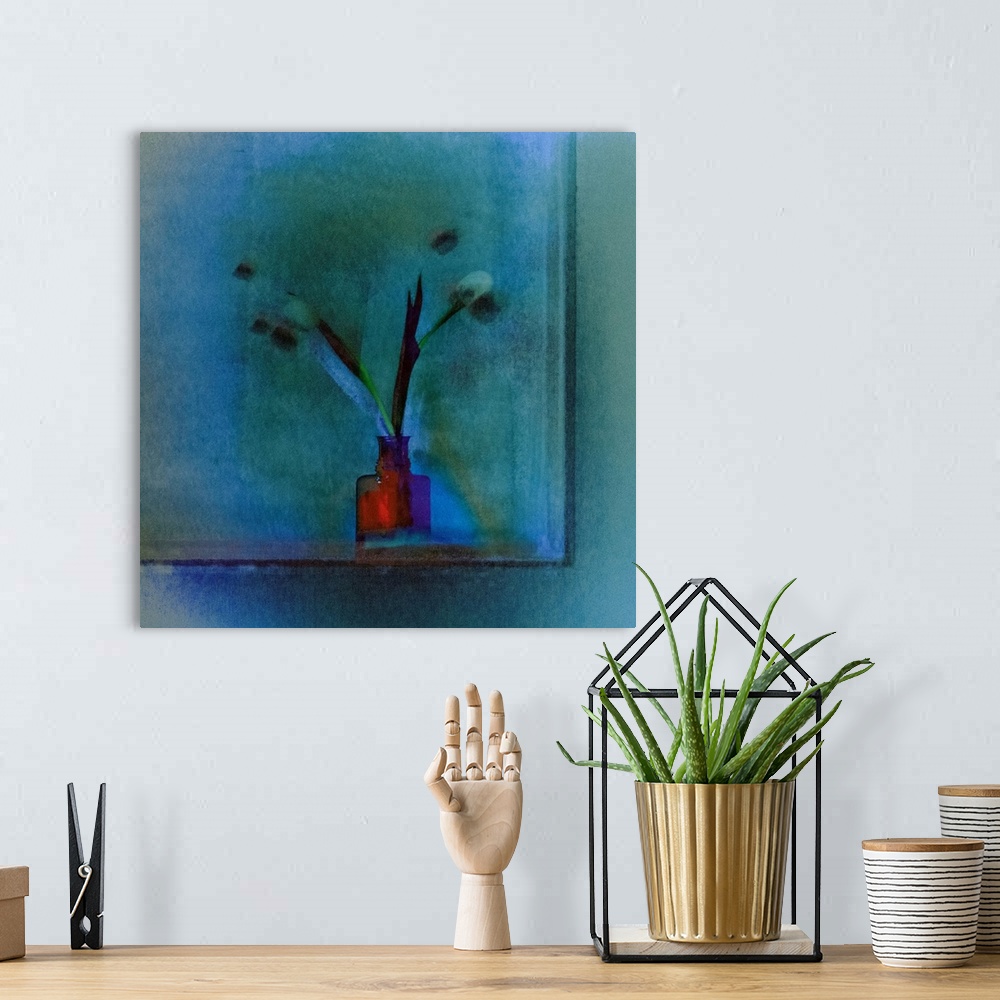 A bohemian room featuring Square image of a bright red vase with long stemmed tulips on a blue background.