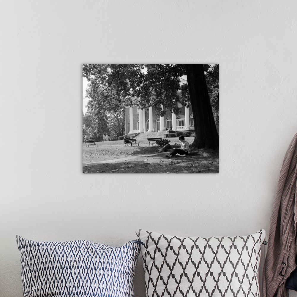 A bohemian room featuring 1960's Anonymous Silhouetted Female College Student Sitting Under Tree Studying With Campus Build...