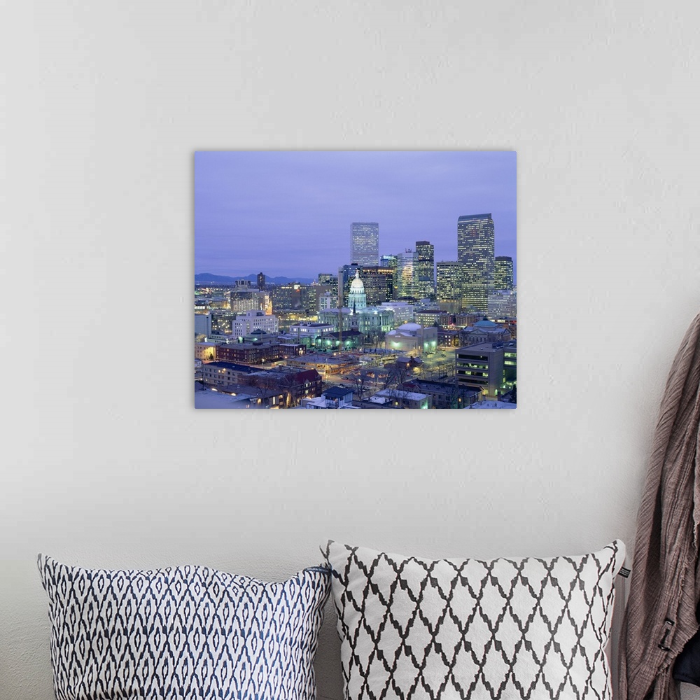A bohemian room featuring Square canvas photo of a illuminated city at dusk with mountains in the left background.