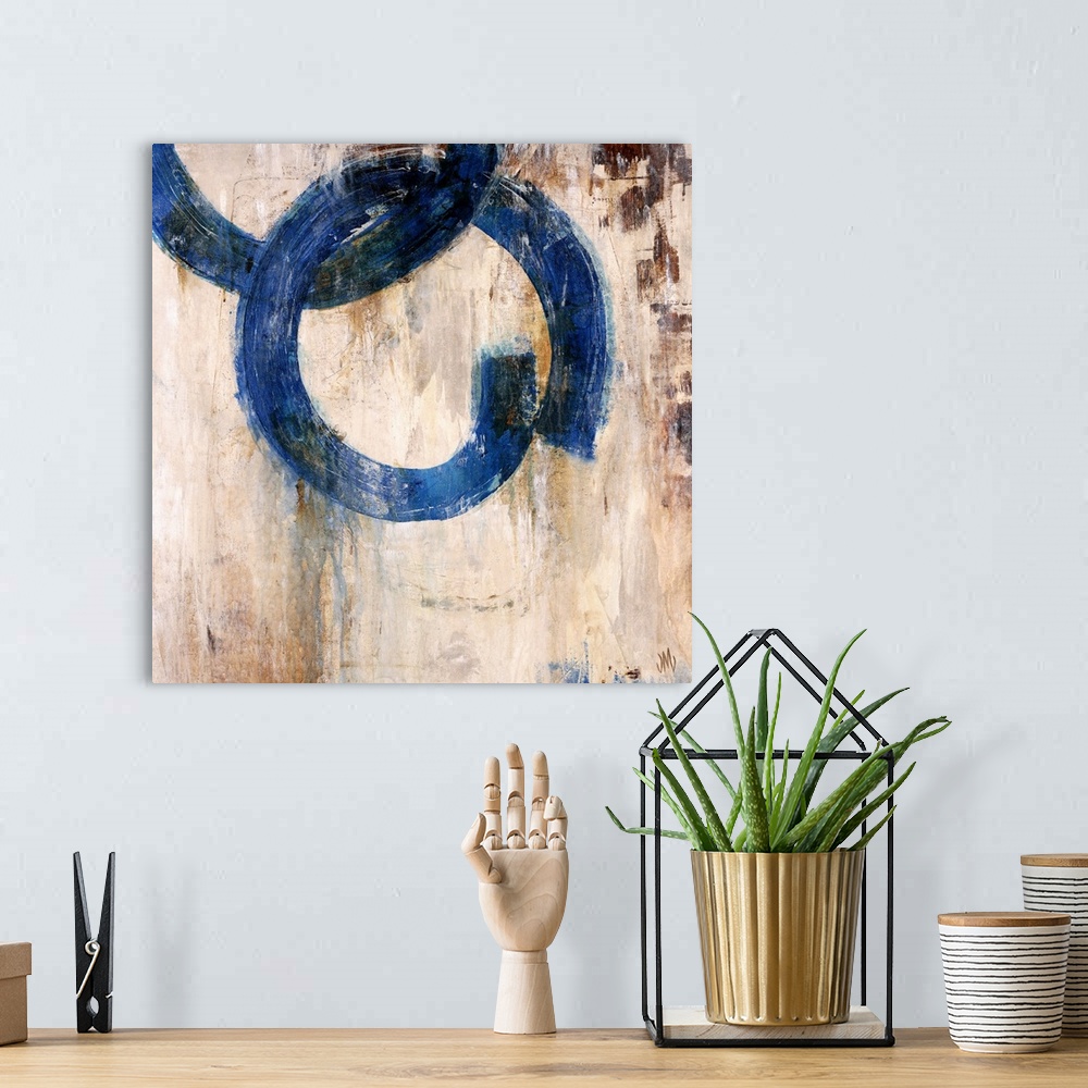 A bohemian room featuring Abstract artwork of a mostly neutral background that has two blue rings that are interlocked.